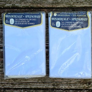 Puede incluir: Dos paquetes de fundas de almohada Wondercale de Springmaid. Cada paquete contiene dos fundas de almohada estándar, que miden 50,8 x 66 cm. El embalaje incluye el texto "No Iron". Las fundas de almohada son blancas y están empaquetadas en plástico transparente.