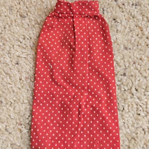 May include: A red skirt with white polka dots. The skirt has a waistband and a straight hem.