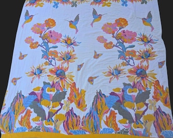 Manta de estilo bohemio con un vibrante estampado floral de girasoles, colibríes y mariposas.