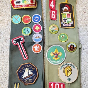 Peut inclure: Deux bandes de tissu vert olive avec divers écussons brodés. Les écussons comprennent des textes tels que "Shenandoah Area Council", "Camp Easton" et "Scoutmaster". D'autres écussons présentent des symboles tels qu'un voilier, une croix et un nageur.