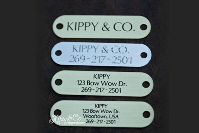 May include: Four different dog tag designs with the name "Kippy" and the text "Kippy & Co."  The tags are made of metal and have a hole for a ring. The tags are all different sizes and have different designs.