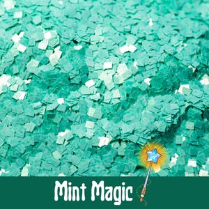 May include: A close-up of teal green glitter with a holographic finish. The glitter is in the shape of small squares. The text "Mint Magic" is written in a whimsical font at the bottom of the image.