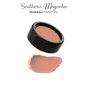 Peut inclure: Un boîtier noir de cosmétiques minéraux avec une poudre de couleur pêche. Une touche du même cosmétique couleur pêche se trouve en dessous du boîtier. Le texte "Southern Magnolia MINERAL COSMETICS" est en haut.