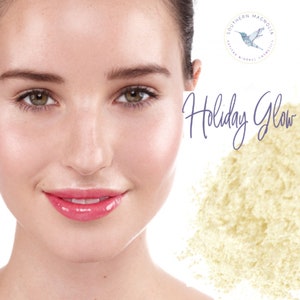 May include: A woman with a glowing complexion, showcasing a light yellow powder with the text "Holiday Glow" and a logo for Southern Magnolia Cosmetics.