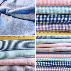 May include: A collection of various fabric rolls in shades of blue, pink, and purple. The fabrics include solid linen, striped patterns, and checkered designs. A wooden ruler with inch markings is visible.