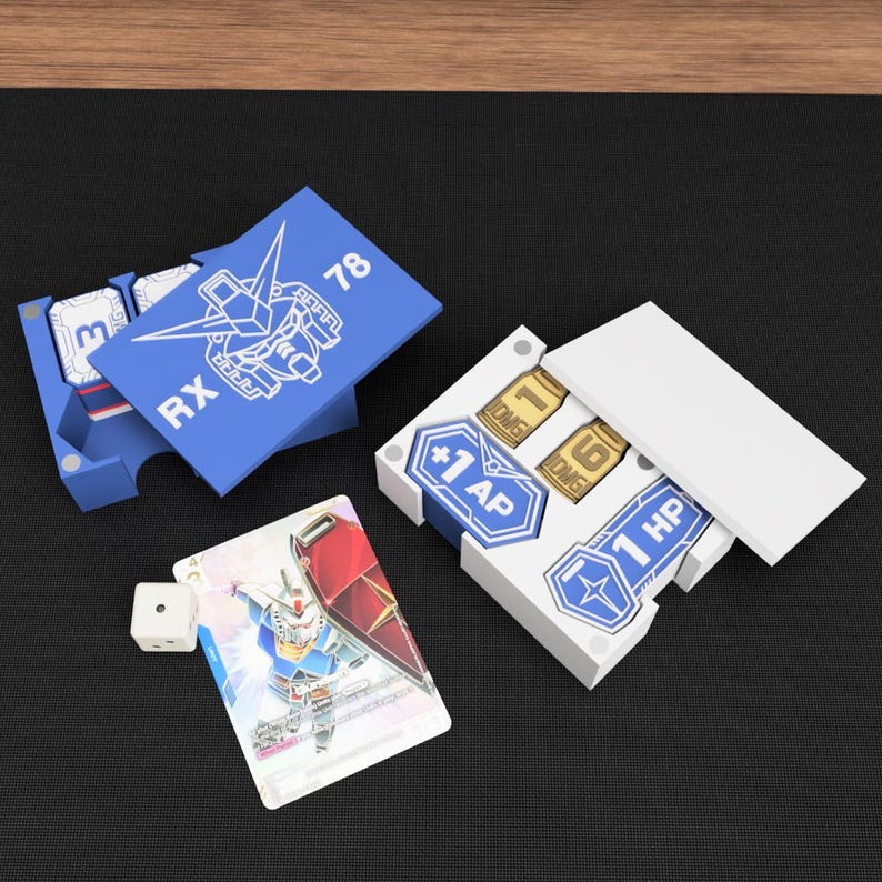 May include: A collection of blue and white game accessories, including card holders and tokens. One card features a robot illustration and the text "RX 78". Other tokens display "+1 AP", "1 HP", and "1 DMG". A white die is also present.