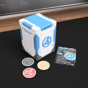 May include: A white and blue rectangular deck box labeled BAXTER with a number 4 logo. Three circular tokens in gray, yellow, and pink with hand icons are placed in front, alongside a blue and black trading card with a matching blue hand token.
