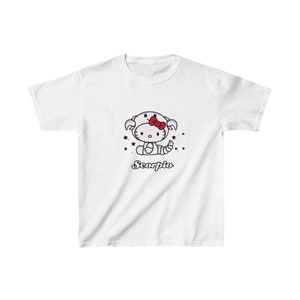 Puede incluir: Camiseta blanca con una ilustración en blanco y negro de Hello Kitty vestida como un signo del zodíaco Escorpio. La ilustración incluye acentos rojos y la palabra "Scorpio" en una fuente roja cursiva.