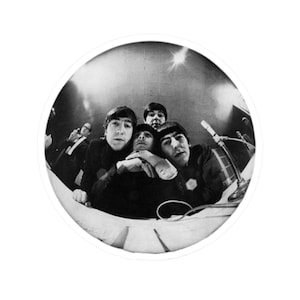 Könnte beinhalten: Schwarz-Weiß-Fotografie der Beatles, einer britischen Rock- und Popband, in einem kreisförmigen Rahmen. Die Bandmitglieder sind eng beieinander und schauen in die Kamera. Ein Mikrofon und ein Mann im Anzug sind im Hintergrund zu sehen.