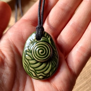 May include: A set of three ceramic mugs with a speckled, matte finish. The mugs are in shades of cream, light gray, and dark gray. Each mug has a simple, minimalist design and a rounded handle.