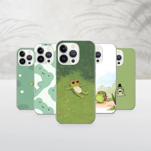 Puede incluir: Cinco fundas para teléfono con diseños de ranas verdes. Una funda muestra una rana con gafas de sol en la hierba. Otras fundas presentan patrones e ilustraciones de ranas.