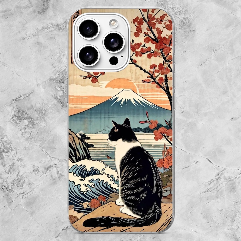 K&ouml;nnte beinhalten: Eine Smartphone-H&uuml;lle mit einem Grafikdruck einer schwarz-wei&szlig;en Katze, die auf einem Felsen sitzt und auf eine Landschaft mit einem gro&szlig;en Berg, einem Gew&auml;sser, brechenden Wellen und einem Baum mit roten Bl&uuml;ten blickt.