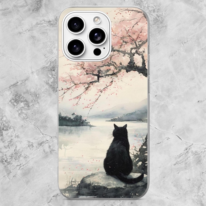 K&ouml;nnte beinhalten: Eine transparente Smartphone-H&uuml;lle mit einem Aquarell-Druck, der eine schwarze Katze auf einem Felsen an einem See zeigt. &Uuml;ber der Katze erstreckt sich ein Kirschbl&uuml;tenbaum mit rosa Bl&uuml;ten. Das Design enth&auml;lt einen Ausschnitt f&uuml;r drei Kameras.