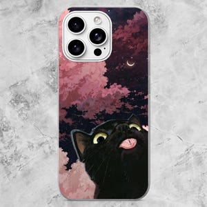 K&ouml;nnte beinhalten: Eine Smartphone-H&uuml;lle mit einem schwarzen Katzenmotiv, das gro&szlig;e gelbe Augen und eine herausgestreckte rosa Zunge zeigt. Der Hintergrund zeigt einen dunklen Nachthimmel voller Sterne, eine Mondsichel und flauschige rosa Wolken.