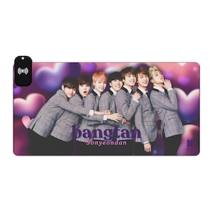 Puede incluir: Un grupo de siete hombres con trajes grises se encuentran juntos sobre un fondo de corazones morados. El texto "bangtan Sonyeondan" está impreso en morado debajo de los hombres.