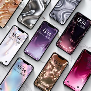 Könnte beinhalten: Eine Ansammlung von Smartphones mit abstrakten, fließenden Hintergrundbildern in Gold, Silber, Lila und Rosa. Auf jedem Bildschirm ist die Uhrzeit "13:14" und das Wort "hello" zu sehen. Die Telefone liegen auf einer weißen Marmoroberfläche. Der Tag ist Montag, 20. Mai.