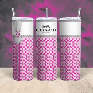May include: Three stainless steel tumblers with pink and white patterned designs. The center tumbler has the Coach logo and the text "New York". The left tumbler has a zipper design with a heart charm.