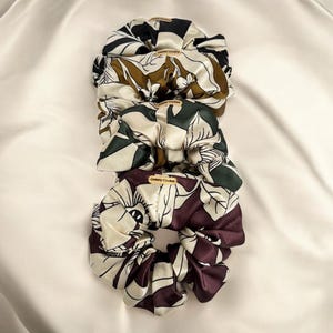 上質なサテン素材を使用した、ハンドメイドの花柄シュシュ。フランス製のシックなヘアアクセサリーです。