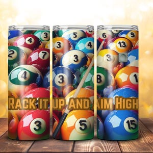Puede incluir: Tres vasos de acero inoxidable con un diseño de bolas de billar de colores. Los vasos muestran un primer plano de bolas de billar con los números del 1 al 15. El texto "RACK IT UP AND AIM HIGH" está impreso en los vasos.