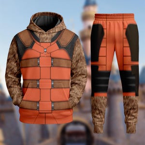 May include: An orange hoodie and matching sweatpants set. The hoodie features a brown and black design with a faux fur hood and sleeves. The sweatpants have a similar design with black accents and faux fur cuffs. The set is designed to resemble a character's outfit.