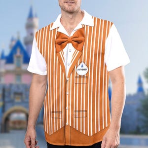 May include: A white short-sleeved shirt with an orange and white striped vest. The vest has a bow tie and a name tag that says "Cast Member".