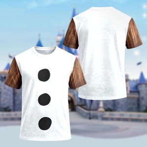 May include: White t-shirt with three black circles down the front, resembling a snowman's buttons. The sleeves are brown, giving the appearance of wooden arms. The shirt is displayed from the front and back.