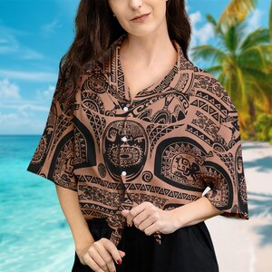 May include: A brown and black patterned shirt with a Polynesian design. The shirt has a button-up front and short sleeves. The shirt is tied at the waist.