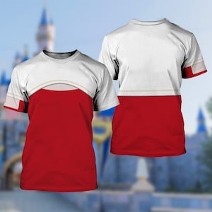 May include: A white and red t-shirt with a unique design. The top portion is white with a curved beige accent, and the bottom half is solid red. The sleeves have a white and red pattern. The shirt is displayed on a blurred background.