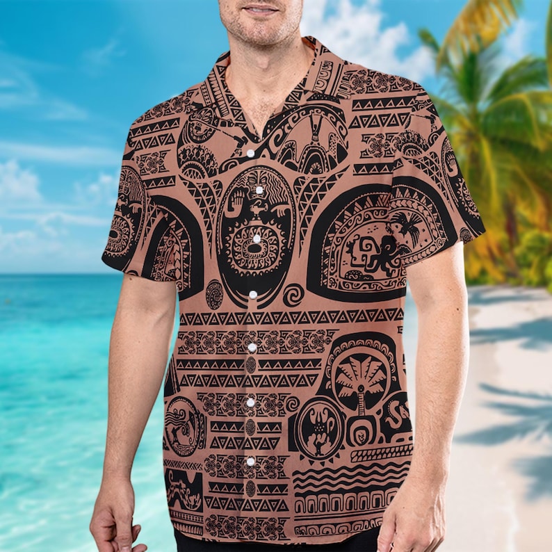 May include: A brown short-sleeved button-down shirt with a black and white Polynesian tattoo design. The shirt features a variety of traditional symbols and patterns.