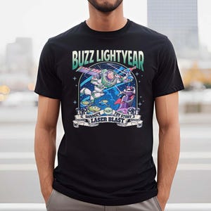 Puede incluir: Una camiseta negra con un gr&aacute;fico de Buzz Lightyear de Toy Story. El gr&aacute;fico presenta a Buzz en el espacio con una explosi&oacute;n de l&aacute;ser y el texto "Buzz Lightyear", "Disney", "Toy Story" y "Laser Blast".