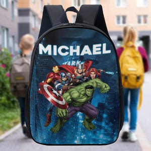 May include: A black backpack with a blue, green, and red graphic of superheroes from the Marvel universe. The backpack has a white zipper and the name "MICHAEL" printed on the front.