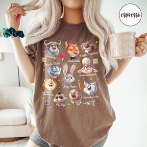 May include: Brown t-shirt featuring cartoon character portraits from the movie Zootopia. Characters include Chief Bogo, Nick Wilde, Judy Hopps, and Flash. The word "espresso" is printed on the upper right corner of the shirt.
