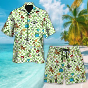 May include: A two-piece matching set featuring a short-sleeved button-down shirt and shorts. The set has a green and white checkered pattern with cartoon character illustrations. The shorts have a drawstring waist. The background shows a beach scene.