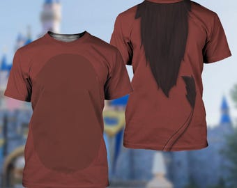 Pode incluir: Uma t-shirt de manga curta e gola redonda num tom castanho-avermelhado sólido. A parte frontal apresenta um painel oval grande e ligeiramente mais escuro ao centro. As costas exibem um gráfico impresso de uma juba castanha e uma cauda fina.