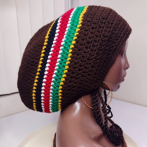 Peut inclure: Béret en crochet marron avec un motif de rayures multicolores. Le motif de rayures est composé de noir, rouge, blanc, vert et jaune.