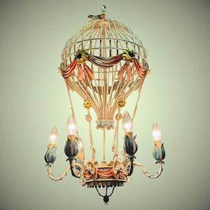 Może przedstawiać: Dekoracyjny żyrandol w kształcie balonu na ogrzane powietrze. Oprawa oświetleniowa ma ptaka na górze, z kremową klatką i jest ozdobiona czerwonymi, pomarańczowymi i złotymi akcentami. Żyrandol ma pięć żarówek.