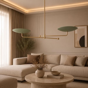 May include: A linear chandelier featuring a thin, vertical brass rod connected to a horizontal bar with two flat, circular, sage green shades extending outward. The fixture has a polished brass finish and a balanced, symmetrical design.