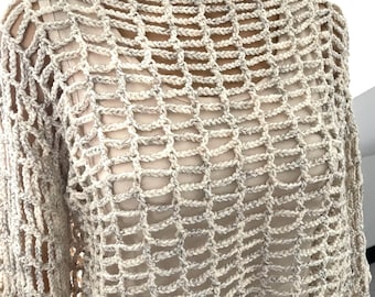 Op de afbeelding: Een beige gehaakt topje met een los, open geweven ontwerp. De top heeft een ronde halslijn en lange mouwen.