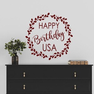 May include: A burgundy red vinyl wall decal with a wreath of leaves and the text "HAPPY Birthday USA".