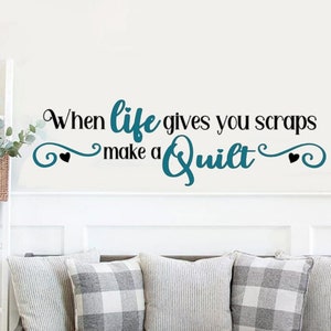 May include: A teal blue and black wall decal with the text "When life gives you scraps make a quilt" with two black hearts on either side of the text.