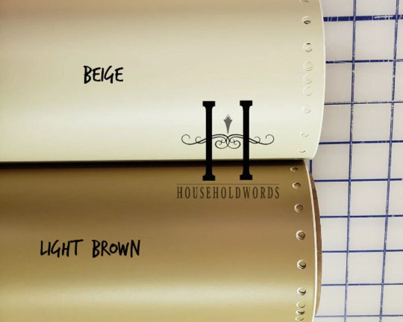 May include: Two rolls of vinyl adhesive film, one beige and one light brown. The rolls are partially unrolled and the text "BEIGE" and "LIGHT BROWN" is visible on the rolls.