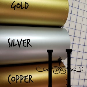 May include: Three rolls of metallic vinyl in gold, silver, and copper. The rolls are labeled with the color names.