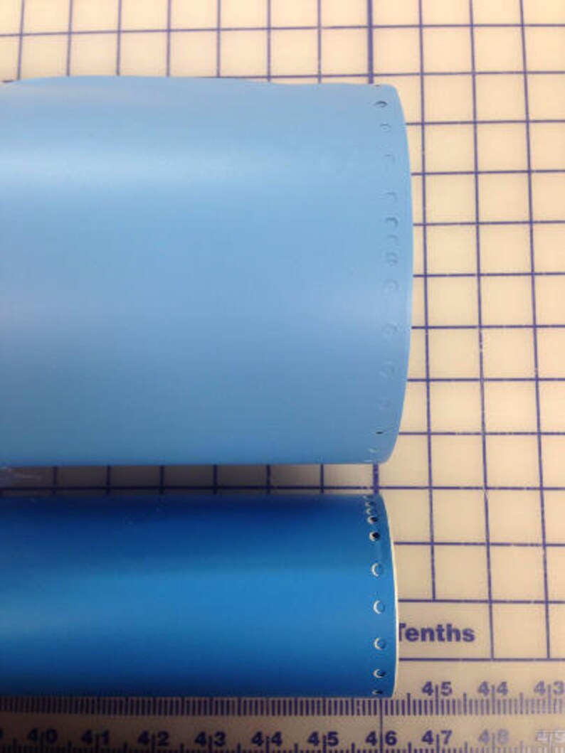 May include: Two blue tubes with a row of holes along the edge. The tubes are on a white grid background with a ruler at the bottom.