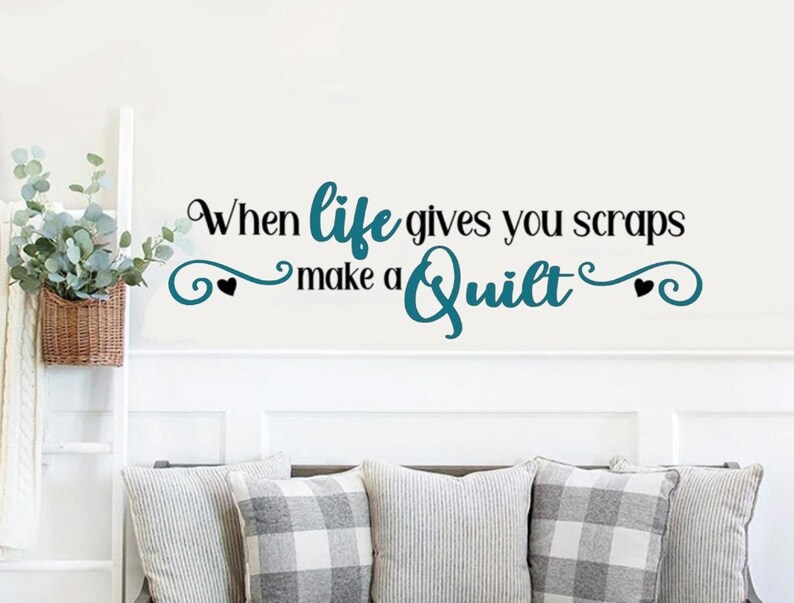 May include: A teal blue and black wall decal with the text "When life gives you scraps make a quilt" with two black hearts on either side of the text.