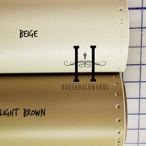 May include: Two rolls of vinyl adhesive film, one beige and one light brown. The rolls are labelled with the colour names and the brand "HOUSEHOLDWORDS".