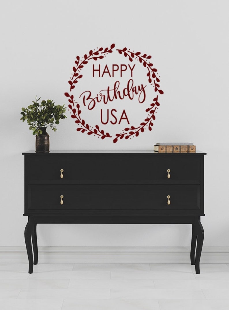 May include: A burgundy red vinyl wall decal with a wreath of leaves and the text "HAPPY Birthday USA".