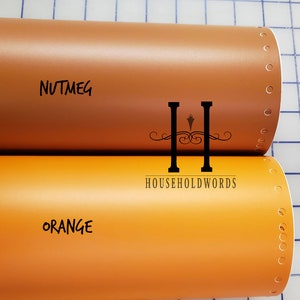 May include: Two rolls of vinyl adhesive film, one in a light brown color labeled "NUTMEG" and the other in a bright orange color labeled "ORANGE". The rolls are partially unrolled and have a perforated edge.