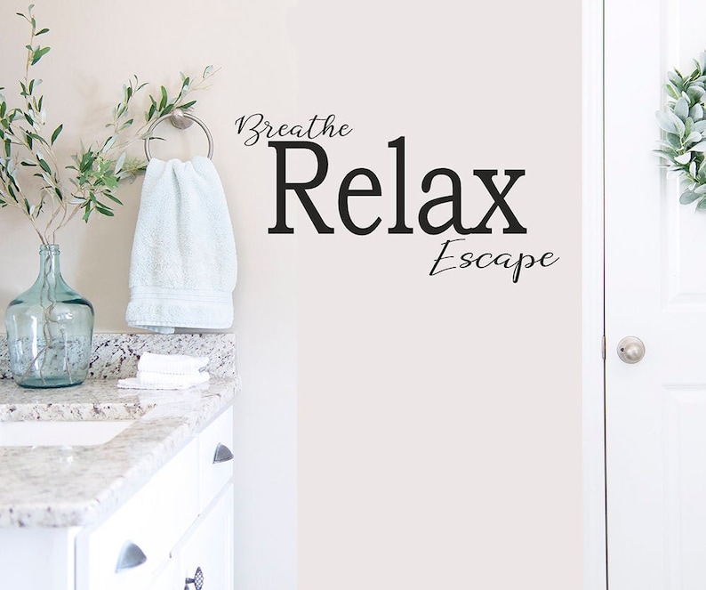 May include: White bathroom wall with a black vinyl decal that reads "Breathe Relax Escape".