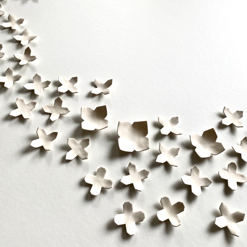Original ceramic wall art shown slightly from the side. Designed for interior decoration wall art decor.
Each piece has four points, some with sharper points and some with curved edges.