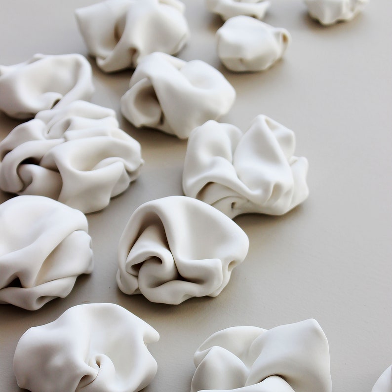 Close up and side view of the original ceramic sculptures. Each sculpture is handcrafted here in my studio. Each piece is different and unique. They consist of folded clay to create natural forms with curves.